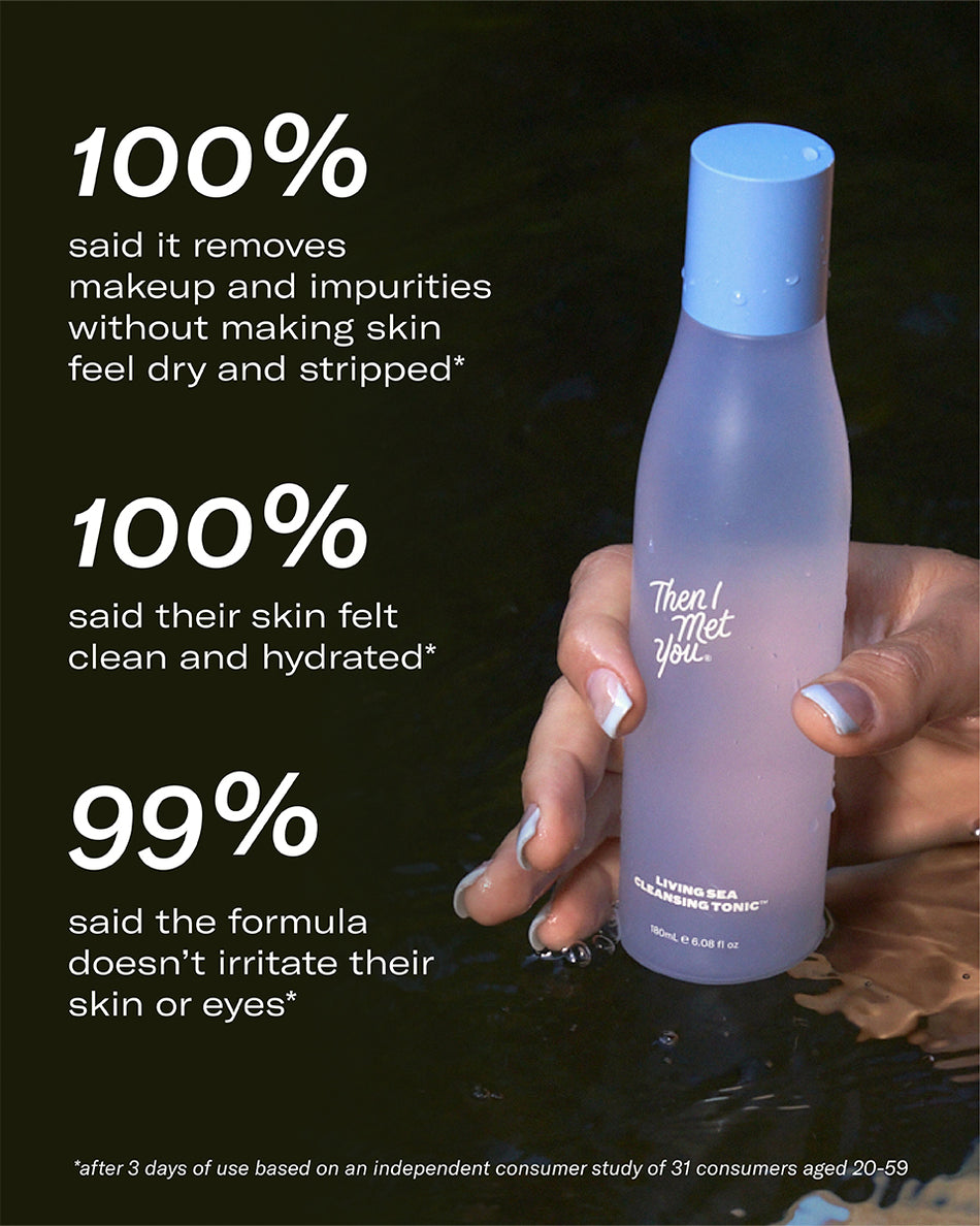 Living Sea Cleansing Tonic travel-size frosted bottle with blue cap held in hand on black background.