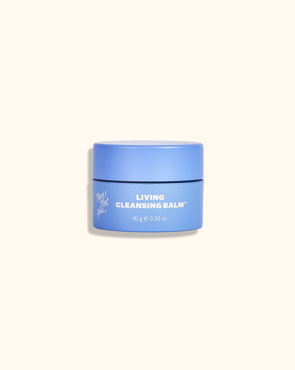 Blue round jar of Living Cleansing Balm Deluxe Mini with white text and floral logo on front.